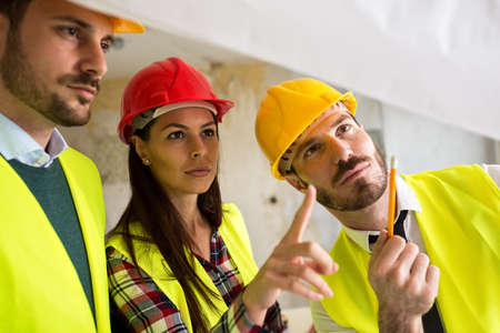 Group of architect watching some details on blueprintsの写真素材