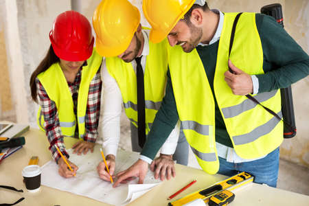 Three  young arhitects working together on construction site project