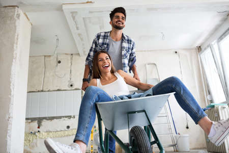 Loving couple is having fun while they are renovating homeの写真素材