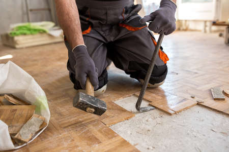 Worker removes old fparquet, renovation home. Construction concept.の写真素材