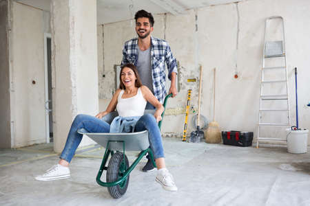 Loving couple is having fun while they are renovating homeの写真素材