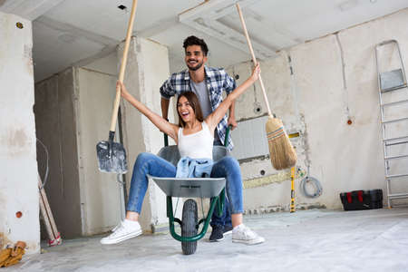 Loving couple is having fun while they are renovating homeの写真素材
