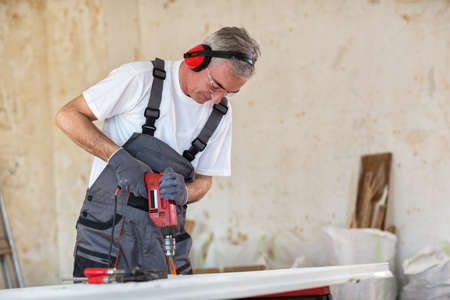 Carpenter used drills  in reparation of old doors in workshopの写真素材