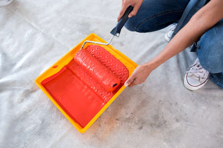 Roller with red color close up, ready for paintingの写真素材