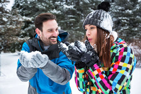 Happy smiling couple on a winter snow day, winter backgroundの写真素材
