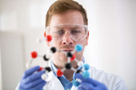 Young scientist holding molecular model at private clinicの写真素材