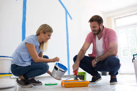 Young happy couple choosing colors for painting their home