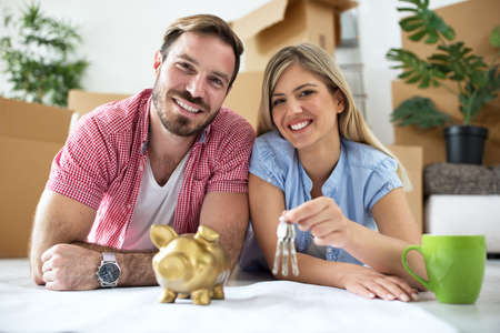 Young smiling couple holding keys at new apartment