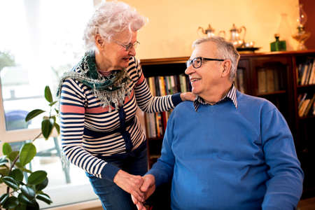 Senior woman take care of her old lovely husband in wheelchairの写真素材