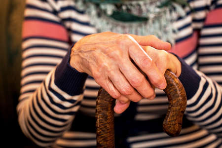 Close up of old woman hands holding stickの写真素材