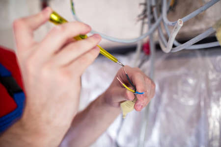 Handyman doing voltage checking with insulated screwdriverの写真素材