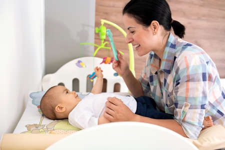 Young mother enjoying time and relaxing through playing with her infant