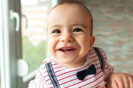 Just a cute baby smiling and laughing at the camera with innocence in his eyes