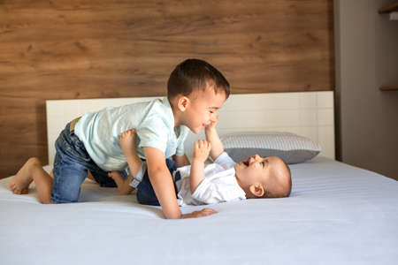 Band of two brothers on the couch playing together  with joy and cheerfulnessの写真素材