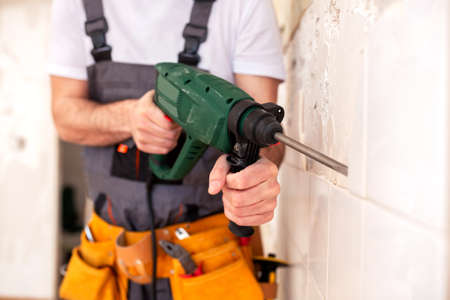 Close up of removing kitchen tiles with a multi-purpose drill