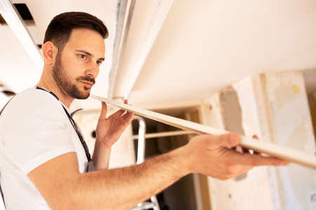 Checking the surface smoothness of a ceiling element by the eye of an experienced handyman