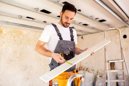 Taking the exact measure of thin wooden board is crucial for correct fitting on the ceiling