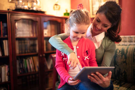 Loving mother explaining to her child how to use a tablet in a correct wayの写真素材