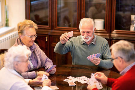Senior people playing card games and having fun in doing soの写真素材