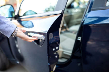Close up of a hand holding the door handle, fancy car door, cool watchの写真素材
