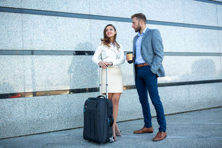 Classy man and a stylish woman standing in front of the buildingの写真素材