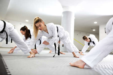Sports and para-sports athletes training martial art of taekwondo together, stretching conceptの写真素材
