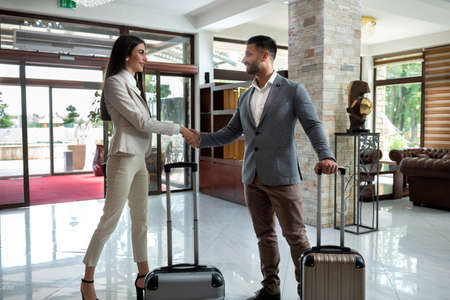 Two elegant business people shaking their hands, and departing waysの写真素材