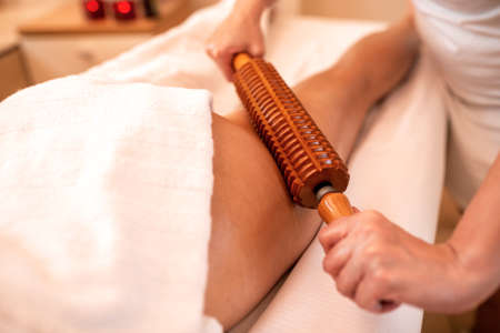 Wooden instruments in maderotherapy applied on the thigh area, anti-cellulite conceptの写真素材