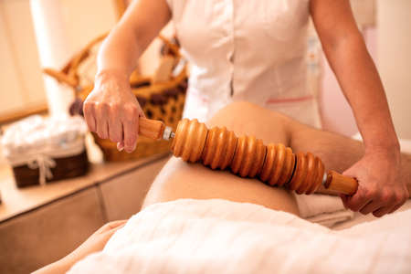 Madero therapy with wooden tools applied on thigh areaの写真素材