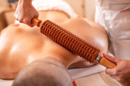 Special massage with a wooden roller tool, blood flow stimulation massageの写真素材