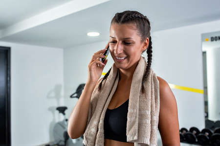 Young girl holding a phone in the gym, phone breakの写真素材