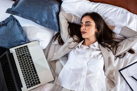 Business woman napping next to her laptop, beauty sleepの写真素材