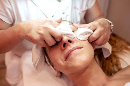 Older woman in a beauty salon having her face cleanedの写真素材