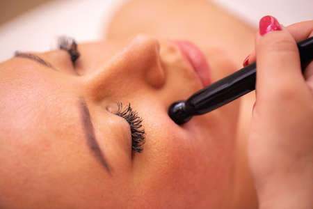 Close up of a womanâ€™s face during a cosmetics treatment with stone wand, healthy facial skin...
