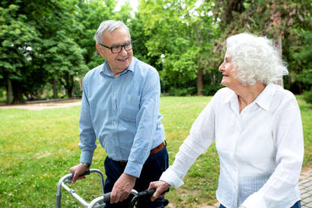 Senior people walking and enjoying a beautiful day in the park using walkersの写真素材