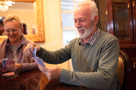 Two senior people looking at their cards preparing for the next moveの写真素材