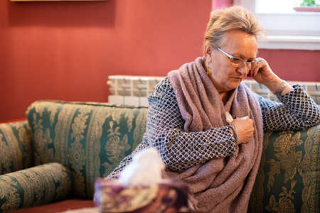 Senior woman coping with depression while sitting downの写真素材