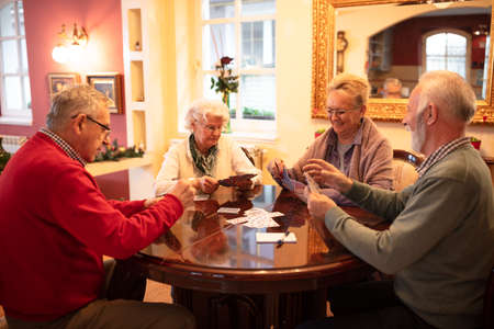 Group of older people entertaining themselves in a card game making time pass fasterの写真素材