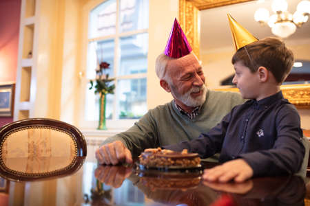 Grandfather and grandson having a party, birthday surpriseの写真素材