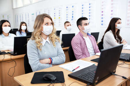 Group of students wearing protection masks in class, prevention concept
