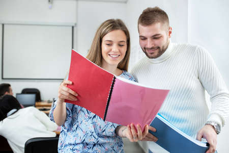 Two young people in the classroom holding and reading from the script, student conceptの写真素材