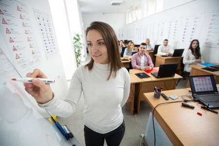 Driving instructor drawing about traffic rules on the whiteboard in the classroomの写真素材