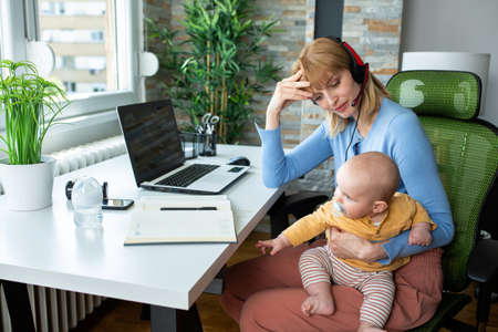 Holding a baby and working from the office not a big problem, only a small oneの写真素材