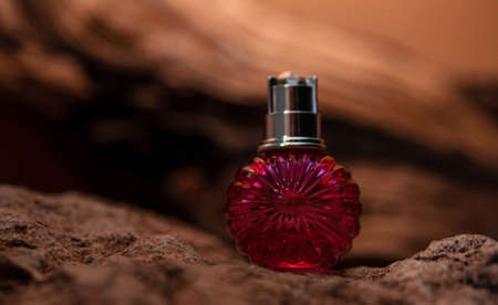 pink bottle nearby cosmetic bottle on wood background stands on stone