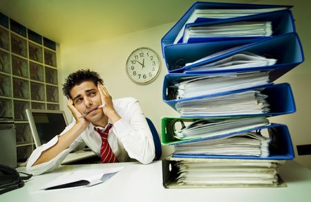 exhausted businessman surrounded by files
