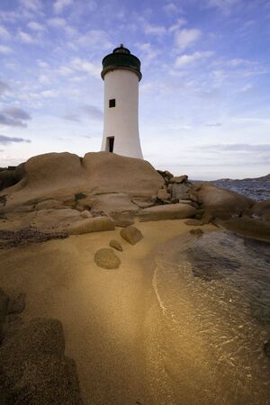 lighthouse seen from a tiny beach in Sardinia.の写真素材