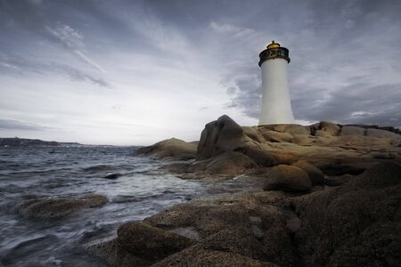lighthouse seen from a tiny beach in Sardinia.の写真素材
