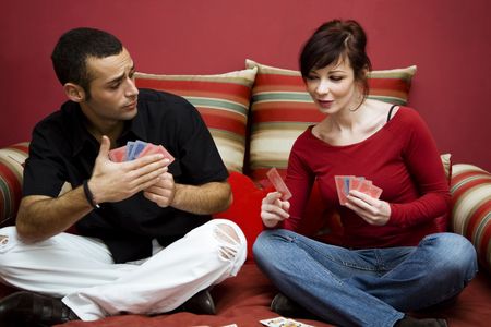 young couple having fun playing cards at homeのeditorial素材