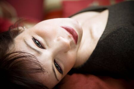 day dreaming: charming woman smiling and looking at the cameraの写真素材