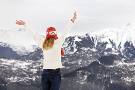 winter scene: blond girl on the top of a mountain. Copy space on the upper sideの写真素材